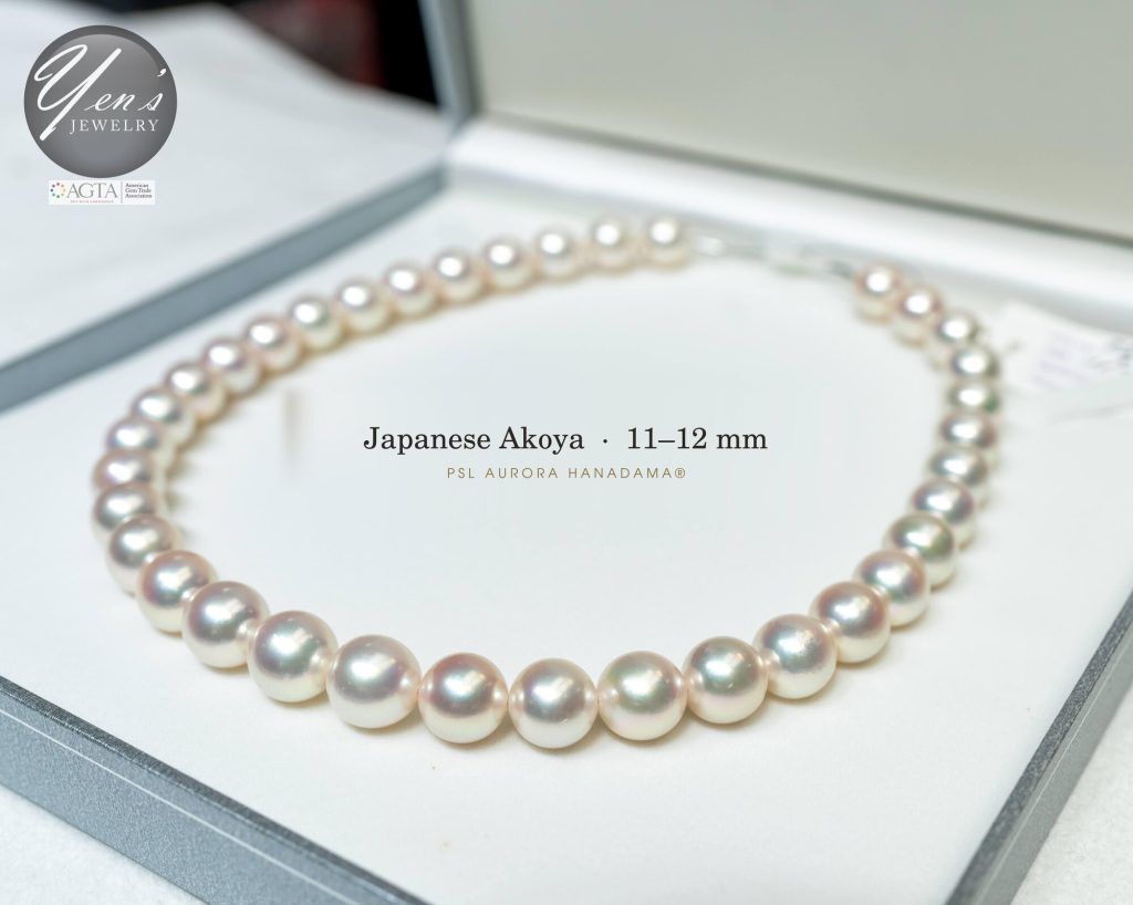 11 to 12 mm Hanadama Akoya strand in its box, angled view showing luster