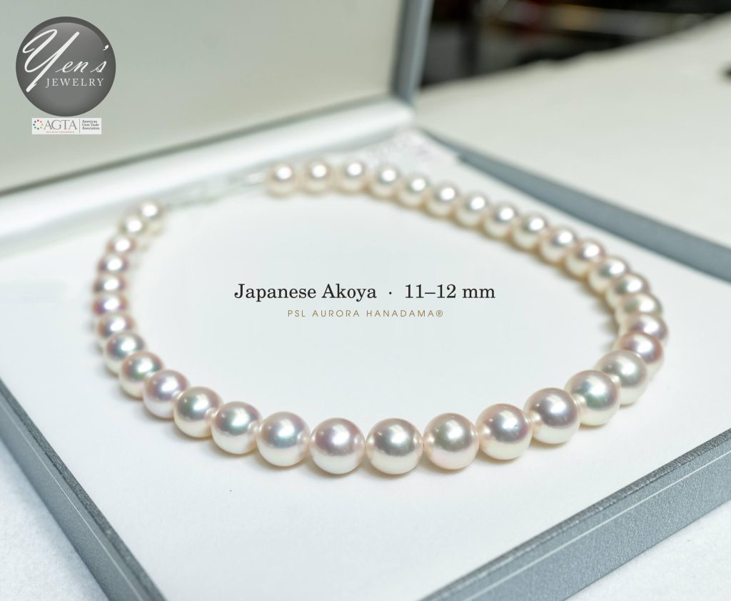 11 to 12 mm Hanadama Akoya strand in its box, side view with pink overtone