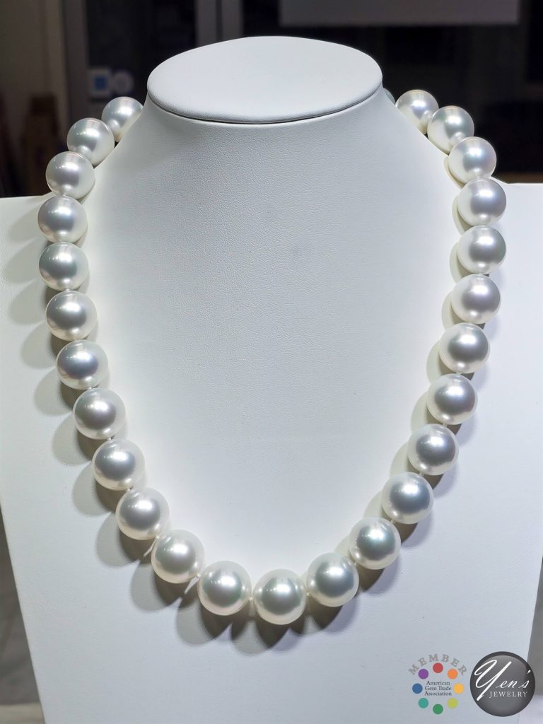 A strand of 17 to 18.7 mm Aurora Venus South Sea pearls with a pave diamond ball clasp on a white display bust