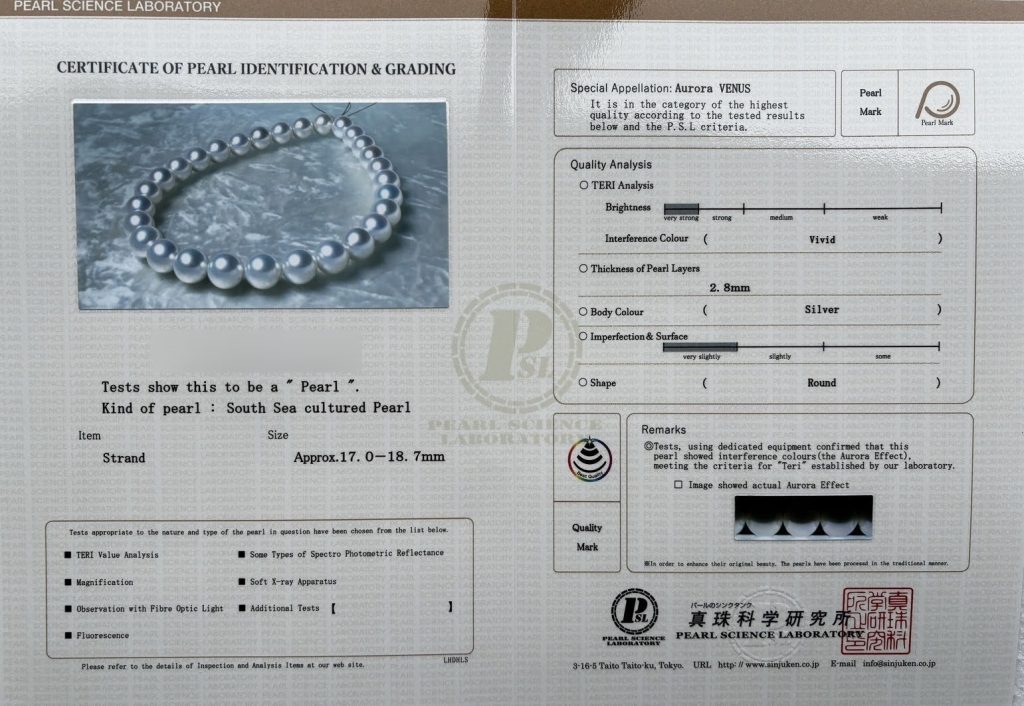 The PSL Certificate of Pearl Identification and Grading for this strand: South Sea cultured pearl, approximately 17.0 to 18.7 mm, special appellation Aurora Venus, very strong brightness, vivid interference color, 2.8 mm nacre, silver body color, very slight imperfections, round. The report number is blurred.