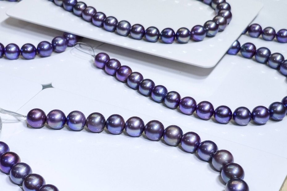 Tanzanite Blue and Amethyst Purple Edison pearl strands laid out on trays, prepared for JCK 2026