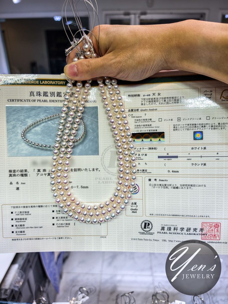 The PSL Certificate of Pearl Identification and Grading: Akoya, approximately 7.0 to 7.5 mm, special designation Aurora Tennyo, pink-green interference, white body color, round series, nacre 0.4 mm. The report number is blurred.