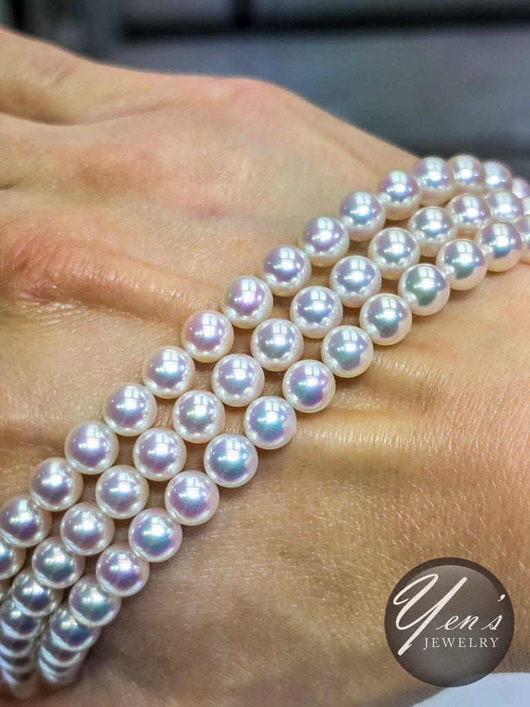 Three Tennyo Akoya strands wrapped across the back of a hand, showing matched size and luster