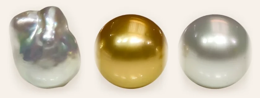 Three South Sea pearls: a white baroque, a golden round and a white round